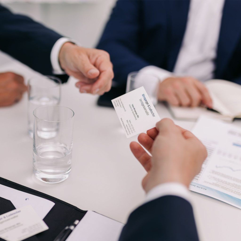 Mitarbeiter der W&L Vermögensverwaltung überreicht eine Visitenkarte